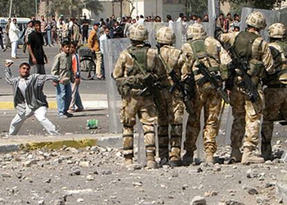 Un joven iraquí lanza una piedra contra soldados británicos durante una manifestación en Basora.