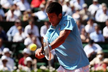 Novak Djokovic golpea un revés ante Ernests Gulbis en las semifinales de Roland Garros.