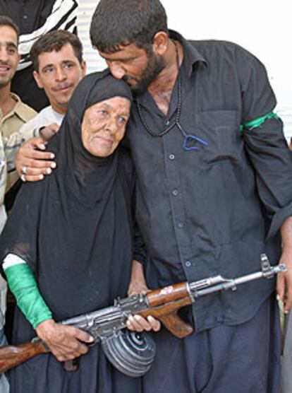 Una anciana iraquí sostiene el fusil de su hijo miliciano en Nayaf.