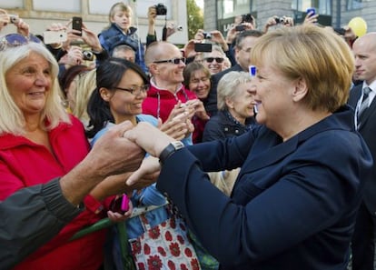 Merkel saluda a la gente en el acto del d&iacute;a de la reunificaci&oacute;n