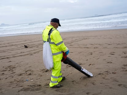 Un operario retira 'pellets', este miércoles en la playa asturiana de Salinas.