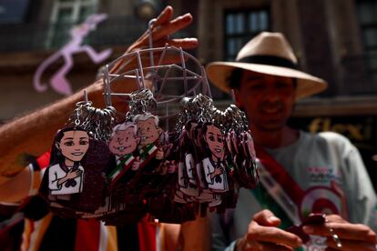 Un vendedor muestra un muñeco con la imagen de López Obrador y Claudia Sheinbaum en el zócalo de Ciudad de México.