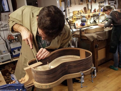 Los hermanos María y Felipe Conde trabajan con dos guitarras en el taller de Felipe Conde, en Madrid.