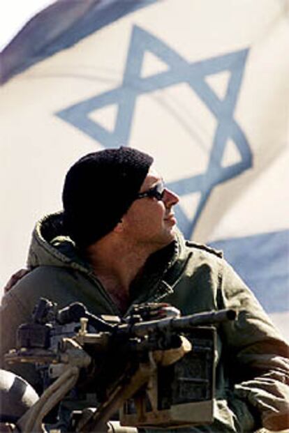 Un soldado israelí contempla su bandera, colocada sobre un tanque desde el que vigila un control a las puertas de Belén.