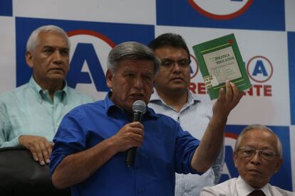 El candidato César Acuña sostiene el libro que plagió