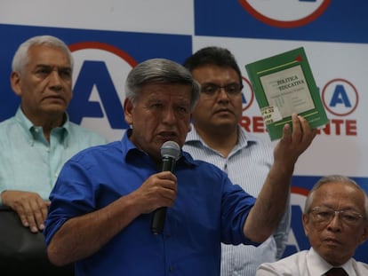 El candidato César Acuña sostiene el libro que plagió