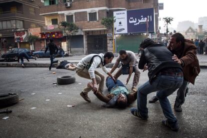 Un partidario del presidente islamista derrocado herido de muerte es evacuado por otros manifestantes durante los enfrentamientos con las fuerzas de seguridad en el distrito Mohandiseen de El Cairo.