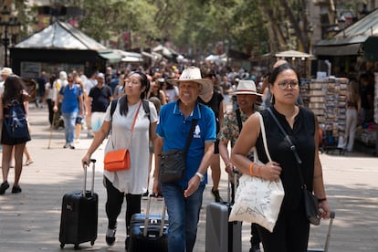 Un grupo de turistas empujando sus maletas en Las Ramblas de Barcelona