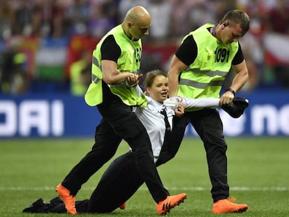 Uma mulher que irrompeu na final da Copa do Mundo é arrastada para fora do campo.