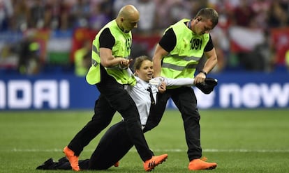 Uma mulher que irrompeu na final da Copa do Mundo é arrastada para fora do campo.