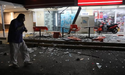 Un hombre contempla los daños en una tienda localizada en la zona hotelera de Acapulco.