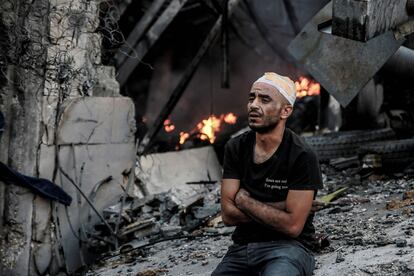Un hombre herido aparece sentado cerca de un edificio afectado por un ataque israelí, este jueves, en Gaza.