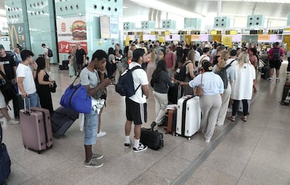 Viajeros ante los puestos de facturación de la terminal 1 de Barcelona-El Prat.