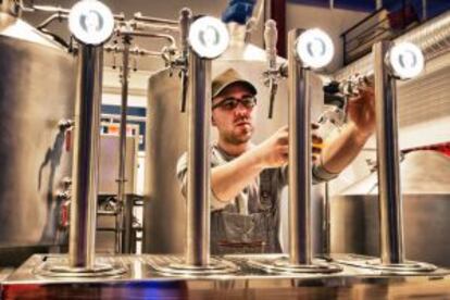 Un trabajador sirve cerveza en la fábrica de La Virgen (Las Rozas, Madrid).