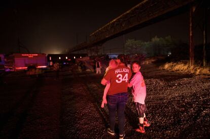 Una mujer y sus hijos observan el sitio donde descarriló el tren de Amtrak que viajaba de Washington a Nueva York.