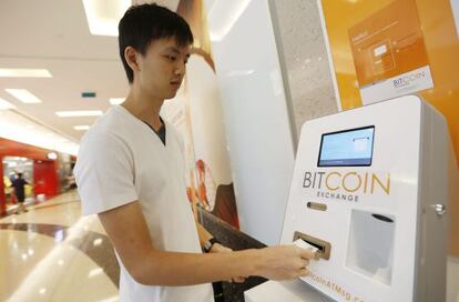 Un empleado hace una demostración de Bitcoin Exchange, un cajero para cambiar bitcoins, en un centro comercial de Singapur.