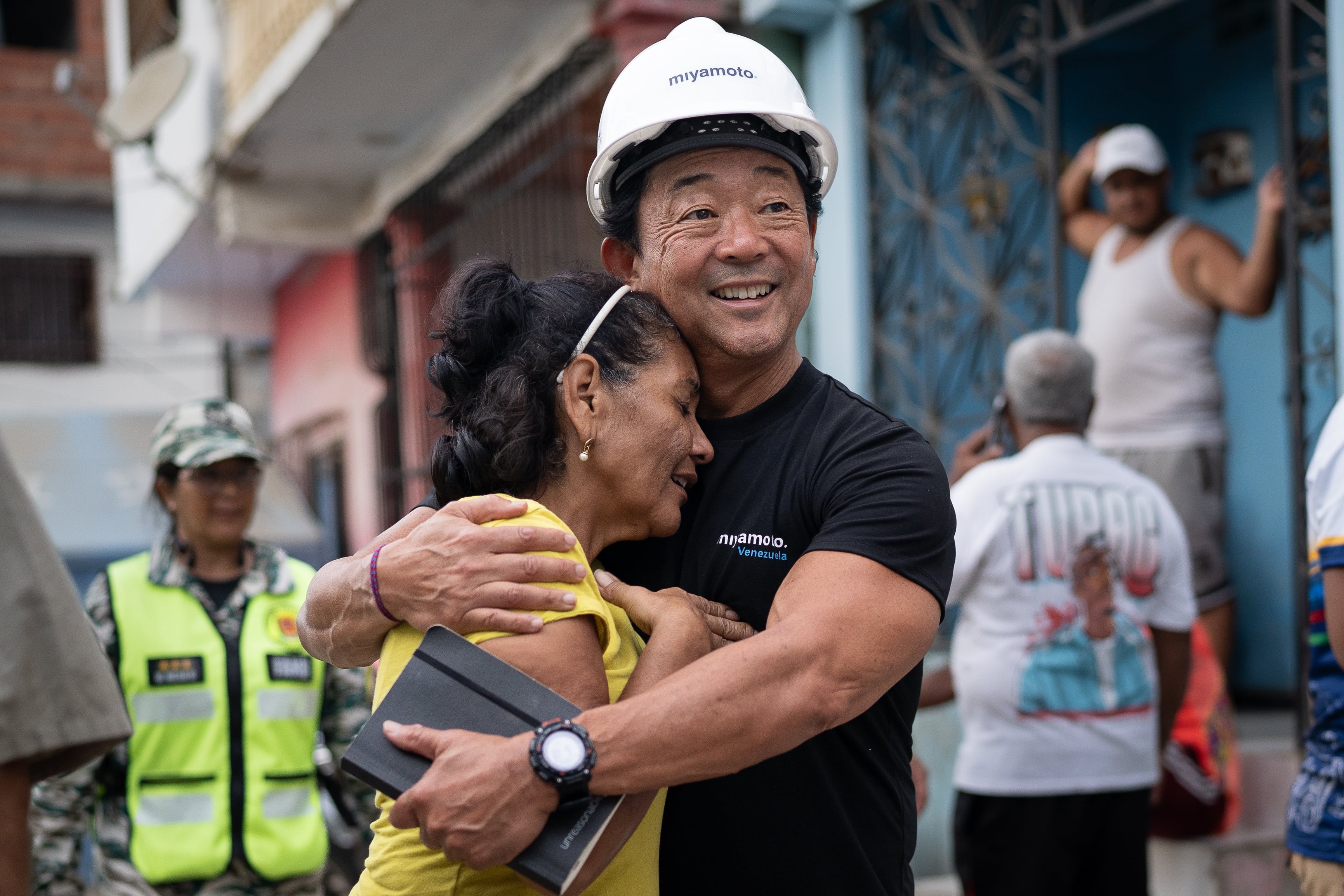 Una mujer abraza a Kit Miyamoto durante una visita de evaluación de las viviendas afectadas.