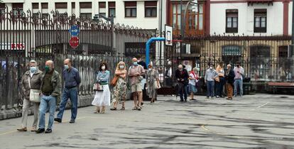 Ciudadanos hacen cola para votar este domingo en un colegio electoral en Bilbao, donde este domingo se celebran los comicios autonómicos vascos.