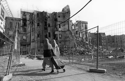 Dues dones caminen entre els edificis derruïts durant les obres que donarien pas a la Rambla del Raval, 1999