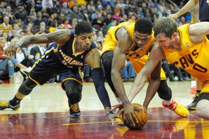 Paul George, de Indiana, pelea un balón con la defensa de los Cavs