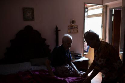 Martina Veranea ayuda a su esposo Donato Hernández de 92 años en su pequeño departamento de Caracas. 