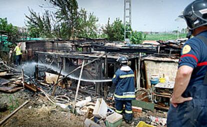 Los bomberos trabajan en la extinción del incendio de la chabola donde murió el niño.