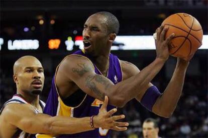 Kobe Bryant protege el balón ante el acoso de Derek Fisher, de los Warriors.