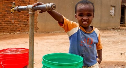 Un niño posa junto al punto de agua potable de su pueblo, Kihurio, en Tanzania.