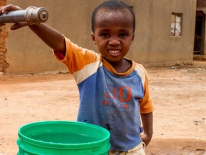 Un niño posa junto al punto de agua potable de su pueblo, Kihurio, en Tanzania.