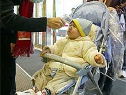 Control de temperatura a un niño en un centro comercial en Taipei (Taiwan).