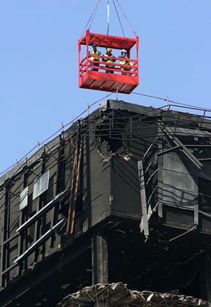 Unos operarios observaban ayer la parte superior del edificio Windsor para comenzar el desmontaje.