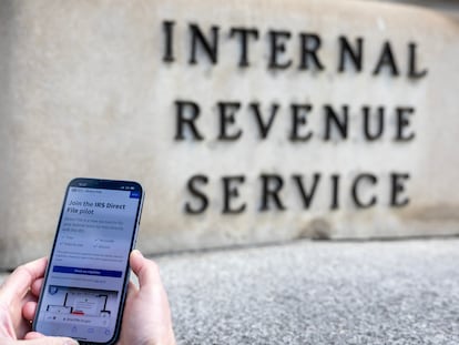 A person uses IRS Free File software in front of the Internal Revenue Service building in Washington (DC).