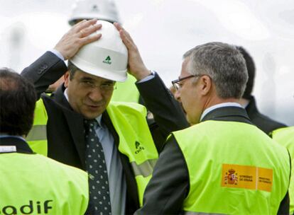 López se pone el casco en presencia de Blanco durante su visita a las obras del AVE vasco.