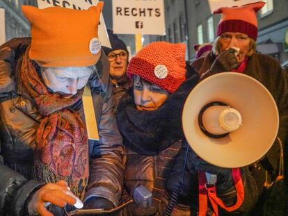 A la derecha, Caroline Koczan repasa las letras de su lema antes de usar el megáfono durante la manifestación contra el Gobierno, en Viena, el 24 de enero.