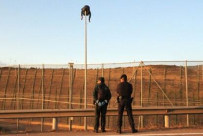 Un inmigrante, subido a un poste junto a la valla, este miércoles.