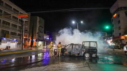 Bomberos apagan una de las patrullas incendiadas, tras el homicidio del estudiante normalisa.