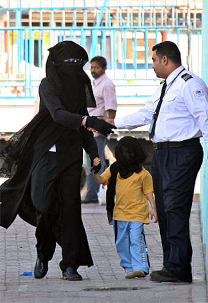 Michael Jackson, vestido con una <i>abaya</i> negra y un velo, saluda a un guarda de un centro comercial de Manama.