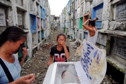 Kasandra Kate (C), de 12 años, llora al lado del ataúd de su padre Verigilio Mirano durante su funeral en el cementerio público de Navotas, en Manila (Filipinas), el 14 de octubre de 2016.