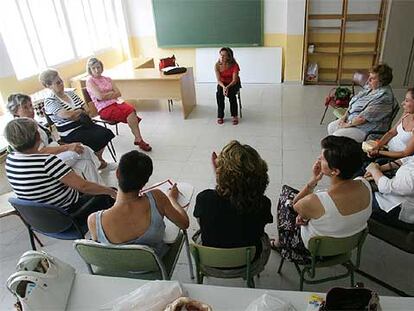 Las mujeres que participan en la terapia de grupo para <i>elaborar</i> duelos, sentadas frente a la psicóloga en Guadarrama (Madrid).
 ULY MARTÍN