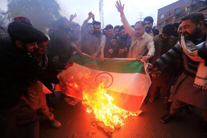 Un grupo de manifestantes gritan consignas y queman una bandera india durante una protesta tras el bombardeo indio en territorio paquistaní, en Peshawar.