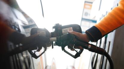 Un operario echa combustible en una gasolinera.