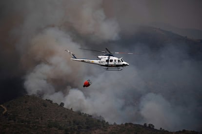 La lucha contra el incendio que se desató el miércoles en el municipio malagueño de Pujerra, en Sierra Bermeja, ha calcinado ya unas 2.000 hectáreas, pero la dificultad para atacar las llamas es máxima. En la foto, un helicóptero participa en la contención de incendios en la Sierra Bermeja, Málaga, este jueves.
