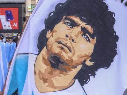 Un aficionado argentino sujeta una pancarta con el rostro de Diego Armando Maradona, que falleció ayer y sumió a la nación en el luto.