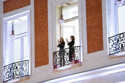 Díaz Ayuso (derecha) se sumó al homenaje a los sanitarios aplaudiendo desde el balcón de la Real Casa de Correos.