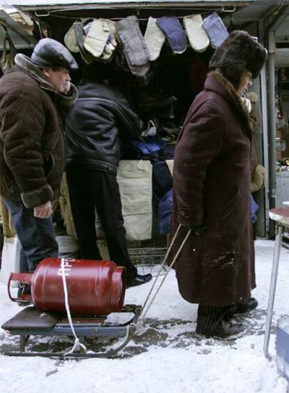 Una mujer ucrania transporta en un trineo una bombona de gas en un mercado de Donetsk, al este del país.