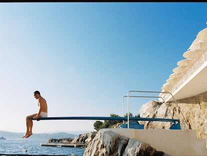 Muros encalados, roca,  el azul del cielo, del mar, y un turista sobre un trampolín de piscina. Pocas combinaciones cromáticas funcionan mejor.