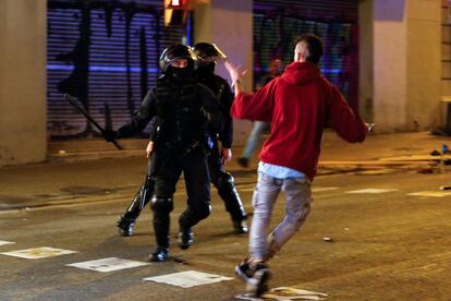 Un 'mosso' carga contra un manifestante durante los incidentes de Barcelona.