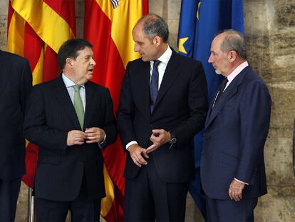 José Luis Olivas, Francisco Camps y Rodrigo Rato, ayer, en el Palau de la Generalitat. Están flanqueados por los presidentes de la Caja Insular de Canarias y Caja Ávila.