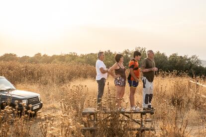 Una familia contempla desde una colina el incendio que amenaza el Parque Nacional de Monfragüe, este sábado.