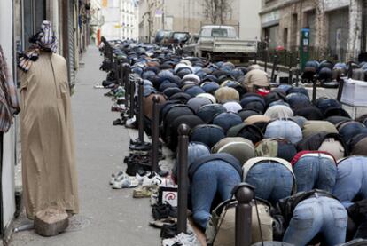 Fieles musulmanes rezan en una calle de París junto a una mezquita.